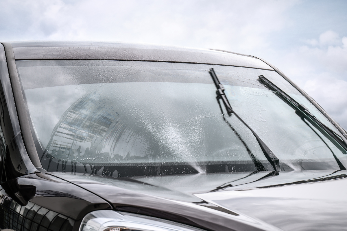 Commercial vehicle windscreen being cleaned with screenwash to improve driver visibility